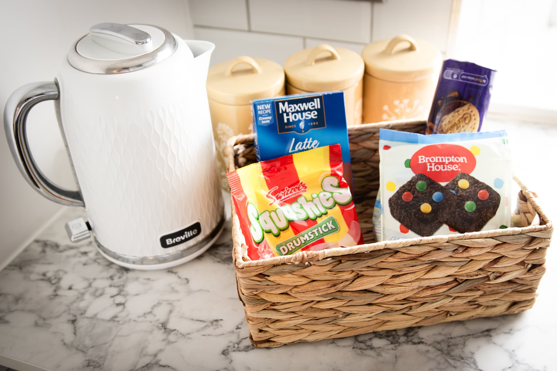 Welcome basket with tea, coffee and treats beside the kettle