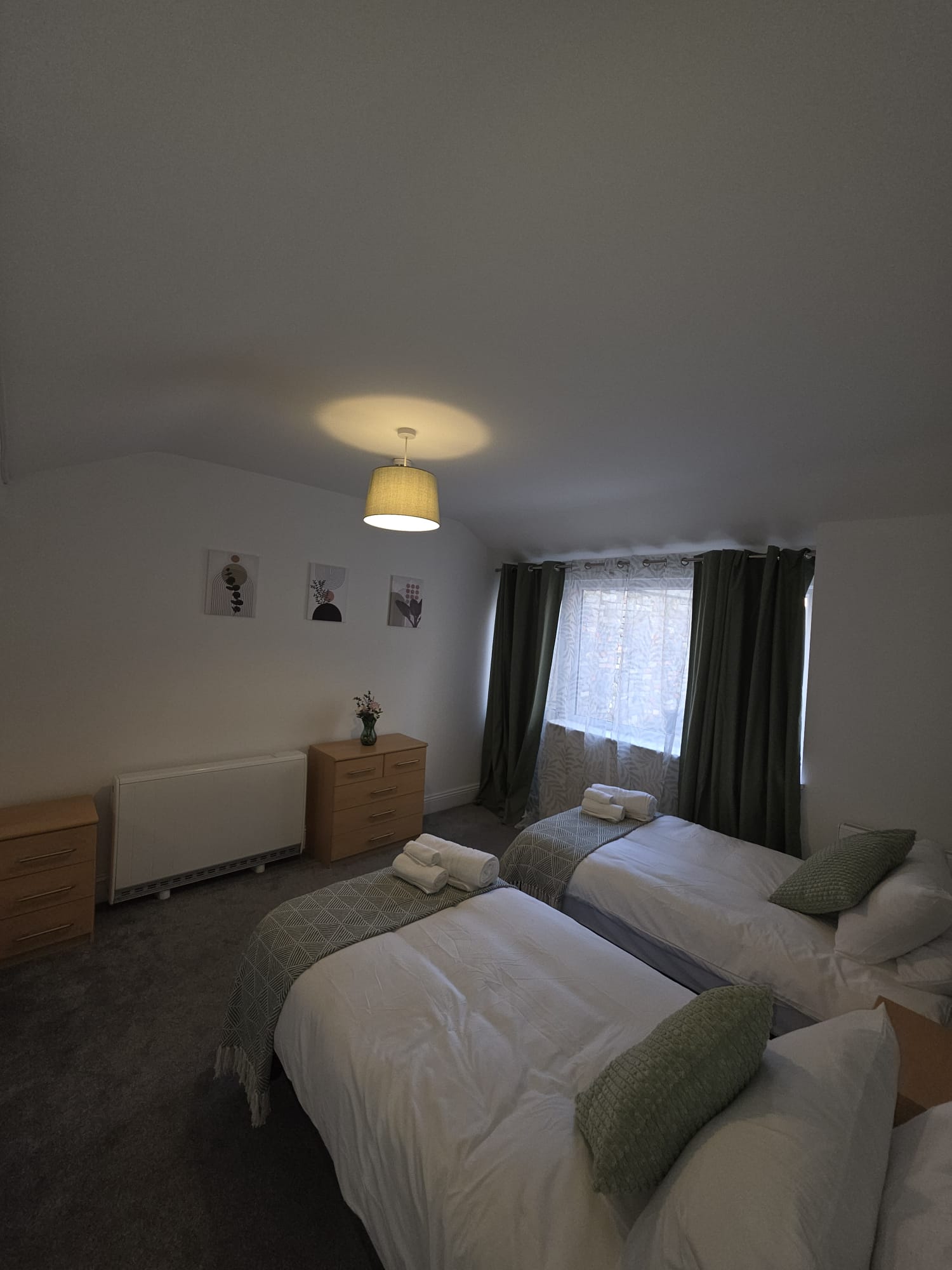 Twin room with bay window, green curtains and chest of drawers