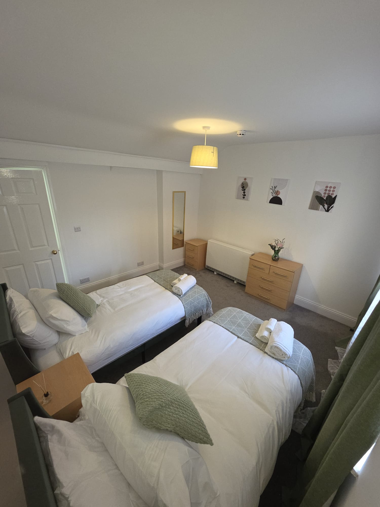 Second twin bedroom with framed prints and fresh towels