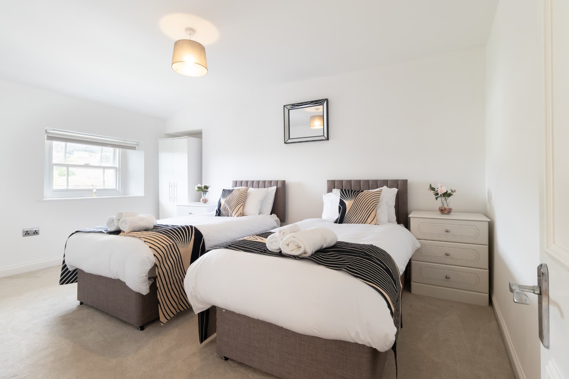 Twin bedroom with fresh white linen and countryside view