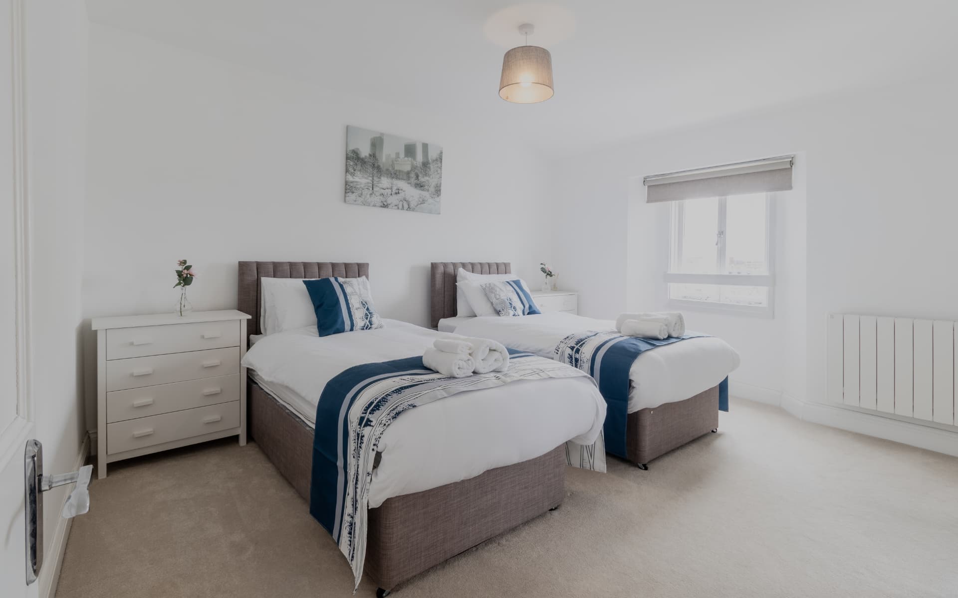 Second twin bedroom dressed in navy and white linen