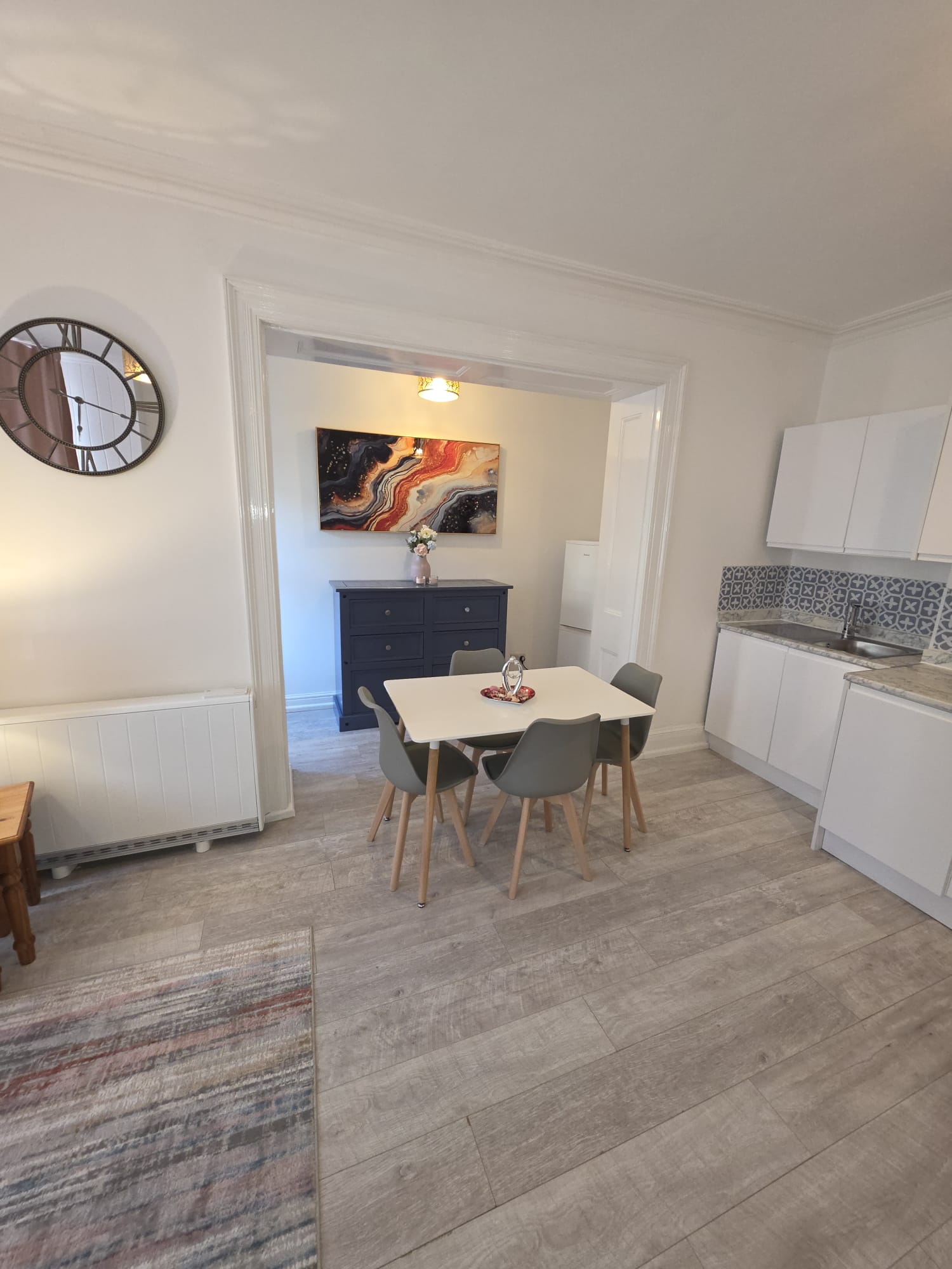 Dining nook with white table for four and navy sideboard